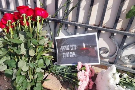 Граждане Казахстана несут цветы к зданию посольства России