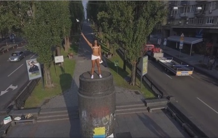 В Киеве активистка Femen забралась на памятник Ленину и разбросала конфеты Roshen