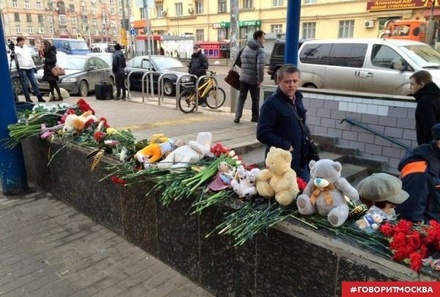 Москвичи несут цветы к входу на станцию метро «Октябрьское поле»